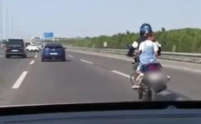 Motosiklet sürücüsü sürətli yolda uşağın həyatını təhlükəyə atıldı